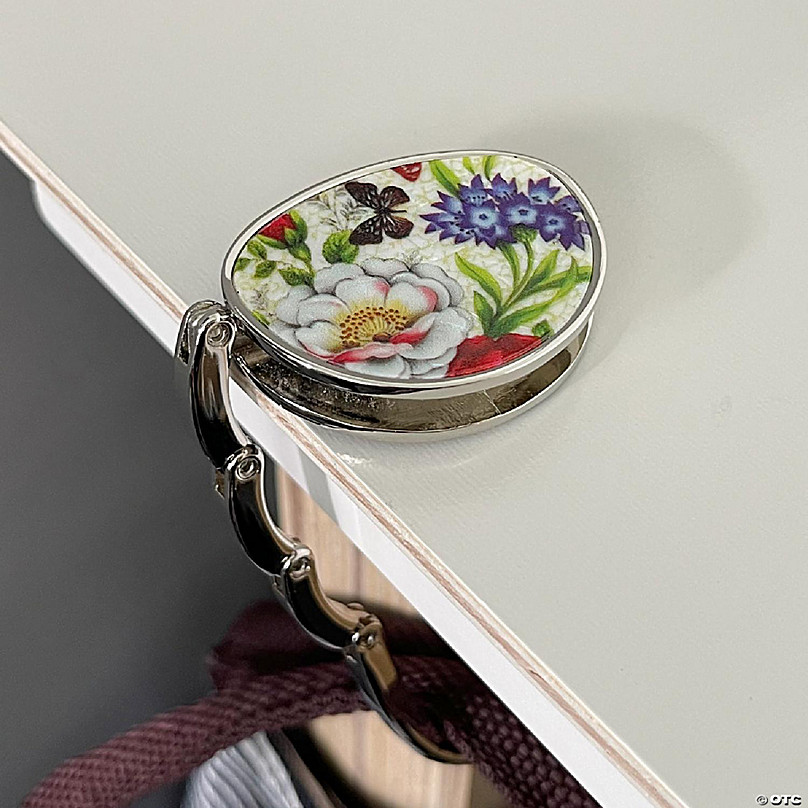 https://s7.orientaltrading.com/is/image/OrientalTrading/FXBanner_808/wrapables-stylish-purse-hook-hanger-foldable-handbag-table-hanger-spring-floral~14411590-a03.jpg